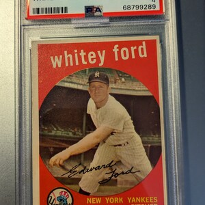 May include: A 1959 Topps baseball card featuring a photo of Whitey Ford, a pitcher for the New York Yankees. The card is graded VG-EX 4 and has a PSA authentication sticker. The card has a red background with a white circle in the center. The circle contains a photo of Whitey Ford pitching. The card also includes Whitey Ford's signature.