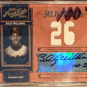 May include: A baseball card featuring Billy Williams, a former Chicago Cubs player. The card is from the 2004 Playoff Prime Cuts MLB Icons series. It features a photo of Williams in his Cubs uniform, his signature, and a piece of his game-worn jersey with the number 26.