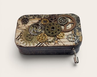 May include: A rectangular box with a map-like design and various metal gears of different sizes and colors on top. The box has a dark, textured exterior and a small metal pull on the side.
