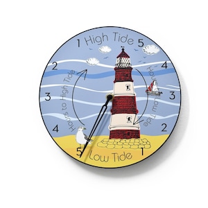 Puede incluir: Un reloj de marea redondo, azul y amarillo con una ilustración de un faro rojo y blanco. La esfera del reloj tiene los números del 1 al 5 y el texto "Horas hasta la marea alta" y "Horas hasta la marea baja".