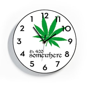 May include: A white round clock with black numbers and hands. A green marijuana leaf is in the center of the clock. The text "it's 4:20 somewhere" is below the leaf.