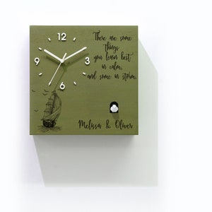 May include: A green wooden cuckoo clock with a white ship and birds design. The clock face has white numbers and hands. The clock has a quote that reads "There are some things you learn best in calm, and some in storm." The clock is personalized with the names "Melissa & Oliver".
