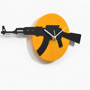 May include: A black silhouette of an assault rifle is used as the hands of a yellow circular clock. The clock is mounted on a white wall. The text "Sol Pixie Dust" is at the bottom of the image.