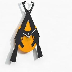 May include: A black wall clock with two crossed rifles forming the clock hands. The clock face is a bright orange circle.