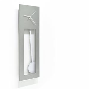 Può includere: Un orologio da parete in metallo argentato con pendolo e quadrante bianco. L'orologio ha una forma rettangolare e una finitura in metallo spazzolato.