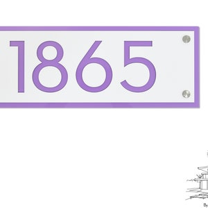 Könnte beinhalten: Ein rechteckiges Hausnummernschild aus weißem Material mit einem violetten Rand und der Nummer 1865 in violetter Schrift. Das Schild ist mit silbernen Schrauben befestigt.