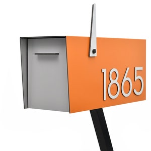 Può includere: Cassetta delle lettere moderna arancione e grigia con un supporto nero e una bandiera argentata. La cassetta delle lettere ha il numero argentato "1865" sul davanti.