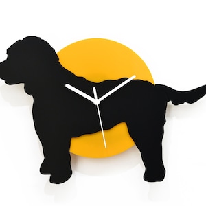 Puede incluir: Silueta negra de un perro con un círculo amarillo detrás. El círculo tiene manecillas de reloj blancas.