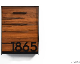 May include: A rectangular wall-mounted mailbox featuring a dark brown wood grain finish, a black metal frame, a horizontal black handle at the top, and the black house numbers 1865 prominently displayed near the bottom edge.