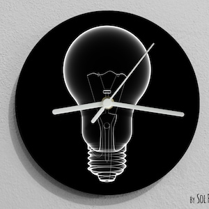 May include: A black and white clock with a light bulb design. The clock hands are white and the background is black.