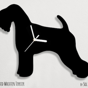Pode incluir: Silhueta preta de um Soft Coated Wheaten Terrier com ponteiros de relógio brancos. O relógio tem a forma do contorno do cão. O texto "SOFT COATED WHEATEN TERRIER" está na parte inferior esquerda da imagem. O texto "BY SOL PIXIE DUST" está na parte inferior direita da imagem.