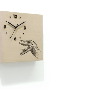 May include: A wooden wall clock with a black clock face and black hands. The clock face has black Roman numeral markings. The clock has a black and white illustration of a dinosaur's head on the bottom right side of the clock face.
