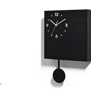 May include: A black square clock with a pendulum. The clock face has white numbers and hands.