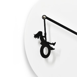 Unieke minimalistische wandklok - Wit en zwart met hangend meisje dat op de band slingert - Wanddecoratie - Uniek cadeau-idee - Kinderkamerdecoratie