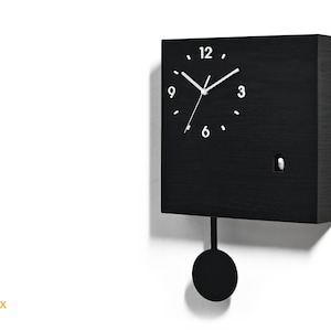 May include: Black square cuckoo clock with a pendulum and white clock hands. The clock face has white numbers 12, 3, 6, and 9.