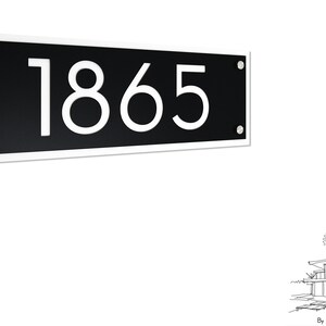Könnte beinhalten: Schwarzes Hausnummernschild mit weißen Zahlen "1865" auf weißem Hintergrund. Das Schild ist mit silbernen Schrauben befestigt.