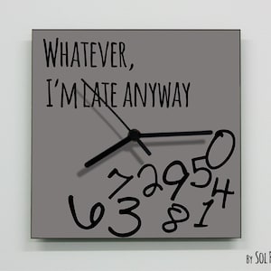 Pode incluir: Relógio de parede quadrado cinza com ponteiros pretos e o texto "Whatever, I'm late anyway". Os números no mostrador do relógio são escritos em um estilo brincalhão e manuscrito.
