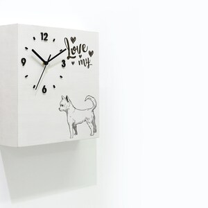 Puede incluir: Reloj cuadrado blanco con agujas y números negros. La esfera del reloj tiene una ilustración en blanco y negro de un chihuahua y el texto "Love my" con corazones.
