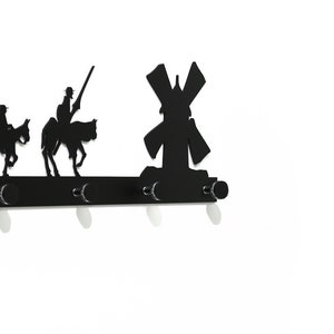以下が含まれることがあります： 風車と馬に乗った2人の人物の形をした3つのフックが付いた黒い金属製の壁掛けフック。フックは、鍵、コート、その他のアイテムを掛けるように設計されています。