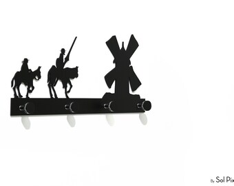 May include: Black metal wall hook with three hooks shaped like a windmill and two figures on horseback. The hook is designed to hold keys, coats, or other items.