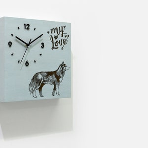 Puede incluir: Un reloj cuadrado azul claro con agujas negras y números negros. El reloj tiene una ilustración en blanco y negro de un perro y el texto "my love" con un símbolo de corazón.