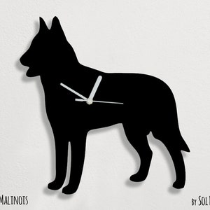 May include: Black silhouette of a Belgian Malinois dog with white clock hands. The clock is labeled "Belgian Malinois" and "By Sol Pixie Dust".