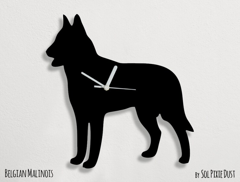 May include: Black silhouette of a Belgian Malinois dog with white clock hands. The clock is labeled "Belgian Malinois" and "By Sol Pixie Dust".