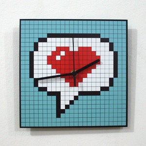 May include: A blue and white pixelated clock with a red heart in the center. The clock hands are black.