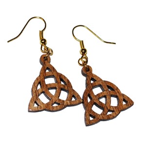 May include: A pair of wooden earrings with a Celtic knot design. The earrings are brown and have gold hooks.