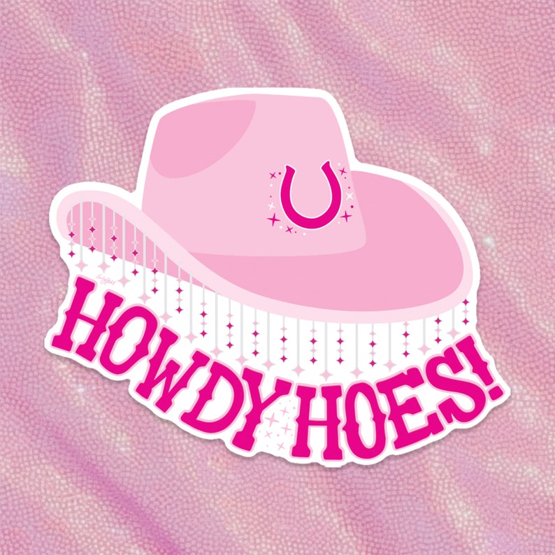 May include: Pink cowboy hat with a horseshoe design and fringe. The hat has the text "Howdy Hoes!" written on it.
