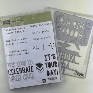May include: A set of two clear plastic packages containing a set of stamps and a set of die cuts for crafting. The stamps feature a cake, candles, and the text "It's time to celebrate with cake." The die cuts feature a speech bubble with the text "Hip Hip Hooray!" and a banner with the text "It's your day!"