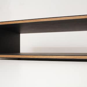 Op de afbeelding: Een rechthoekige houten plank met een open voorkant, een zwart interieur en een natuurlijke houten lijst. De plank heeft een modern design en is geschikt voor het uitstallen van items. De plank is ongeveer 61 cm breed.