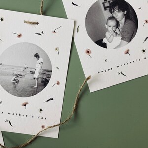 May include: White Mother's Day cards with black and white photos inside a circle, surrounded by small floral and leaf illustrations. The words "happy mother's day" are printed at the bottom of each card. A natural twine string is attached to the cards.
