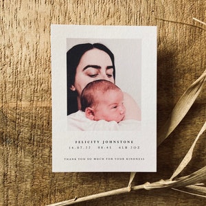 May include: A newborn baby girl is being held by her mother. The baby is wearing a white onesie and the mother is wearing a white shirt. The image is in a soft, warm tone. The text on the card reads "Felicity Johnstone 14.07.22 08:45 6LB 2OZ Thank you so much for your kindness."