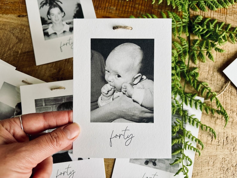 May include: Black and white photo of a baby with the word "forty" written below it.