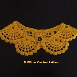 May include: A yellow crocheted collar with a black button in the center. D. Wilder Crochet Pattern is written below the collar.