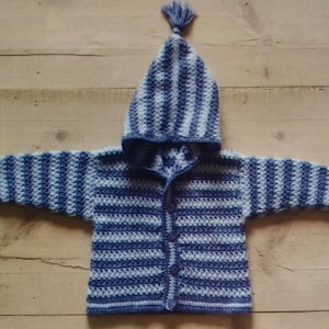 May include: A blue and white striped crocheted baby jacket with a hood and buttons down the front.
