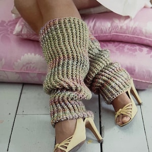 Puede incluir: Un par de polainas de crochet en color verde, rosa y marrón. Las polainas se llevan con sandalias de tacón amarillo.