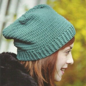 May include: A teal blue crocheted beanie hat. The hat is slouchy and has a simple design.