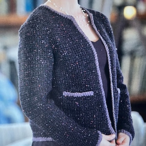 May include: A dark purple crocheted cardigan with a contrasting light purple trim. The cardigan has a V-neck and two pockets.