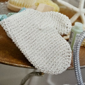May include: A white crocheted exfoliating mitt for use in the shower or bath.