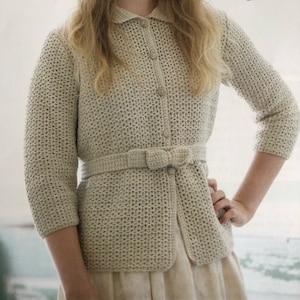Peut inclure: Un cardigan en crochet beige avec un devant boutonné et une ceinture en crochet avec un nœud.