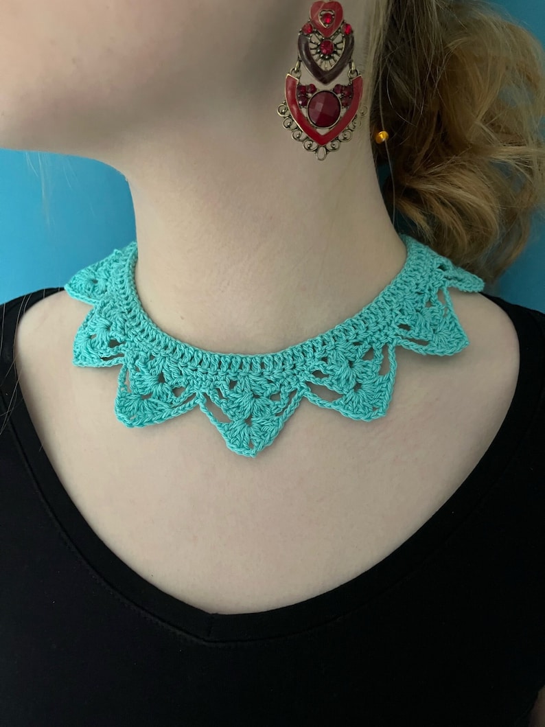 May include: A turquoise crocheted collar necklace with a scalloped edge.