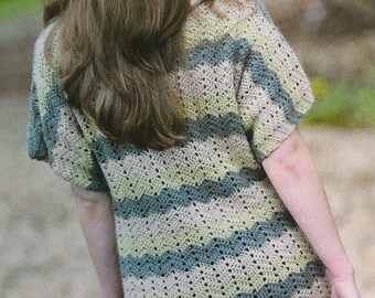 May include: A crocheted top with a wavy striped pattern in shades of green, beige, and blue. The top has a loose fit and short sleeves.