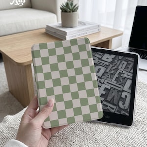 May include: A green and white chequered Kindle cover is held next to a Kindle device. The cover has a light green and white checkerboard pattern. The text "Eternal Creative Arts" is in the upper left corner.