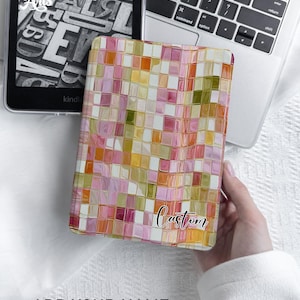 May include: A rectangular e-reader case featuring a mosaic pattern of pink, orange, yellow, and olive green squares. The case includes a white rectangular label in the bottom right corner with the word Custom printed in black script font.