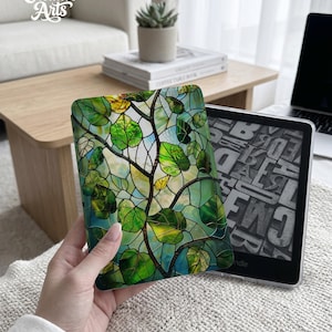 May include: A green and yellow stained glass design Kindle cover featuring a leaf and branch pattern. The cover is held next to a Kindle e-reader. The text "Eternal Creative Arts" is visible in the upper left corner.