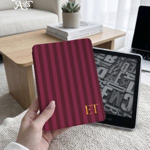 May include: A burgundy and maroon striped e-reader cover with the gold initials "ET". The cover is held next to a Kindle e-reader. The "Eternal Creative Arts" logo is in the upper left corner.