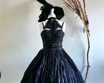 May include: A black lace dress with a full skirt and a black lace choker. The dress is on a mannequin and a witch's hat is on top of the mannequin's head.