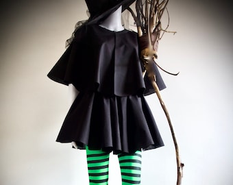 May include: A black witch costume with a black pointed hat, a black cape, and a black skirt. The witch is wearing green and black striped tights and holding a brown twig broom.